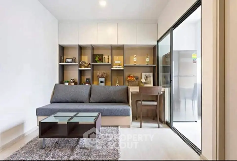 Modern living room with sleek furniture and open kitchen layout in a stylish apartment.