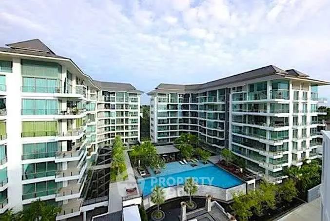 Luxurious modern apartment complex with stunning pool and lush greenery, perfect for upscale living.