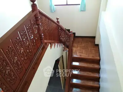 Elegant wooden staircase with intricate railing design in a bright home interior