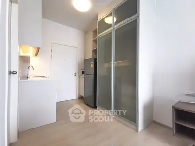 Modern compact kitchen with sleek cabinets and appliances in a minimalist apartment.