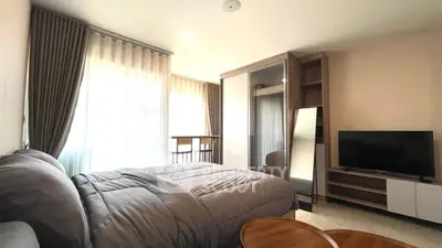 Modern bedroom with cozy bedding, large window, and sleek furniture design.