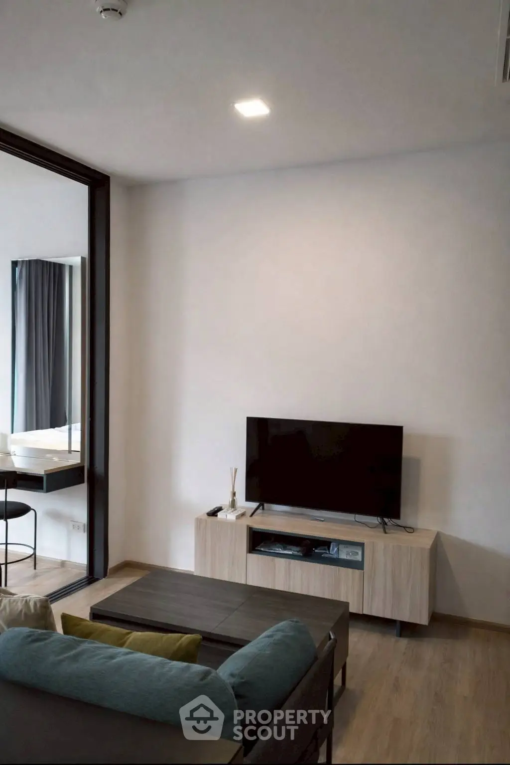 Modern living room with sleek TV setup and stylish furniture in a contemporary apartment.