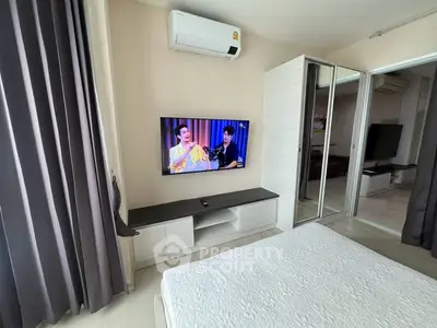 Modern bedroom with wall-mounted TV and air conditioning, featuring sleek design and ample natural light.