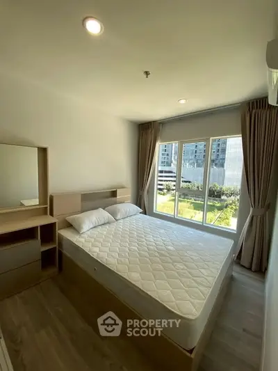 Bright and airy bedroom with large window and modern furnishings