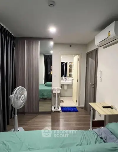 Modern bedroom with ensuite bathroom, featuring sleek wardrobe and air conditioning.