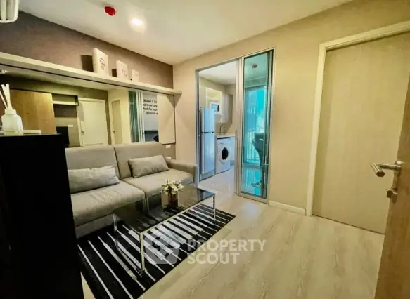 Modern living room with sleek design and adjacent laundry area in a stylish apartment.