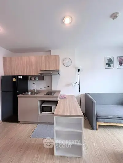 Modern open-layout kitchen with sleek appliances and cozy living area