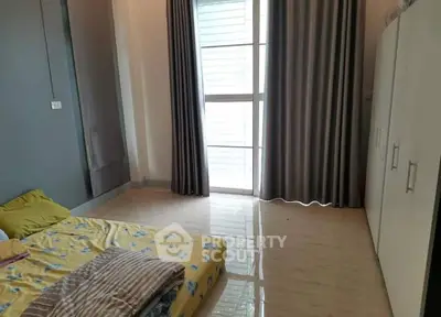 Spacious bedroom with large window and modern wardrobe