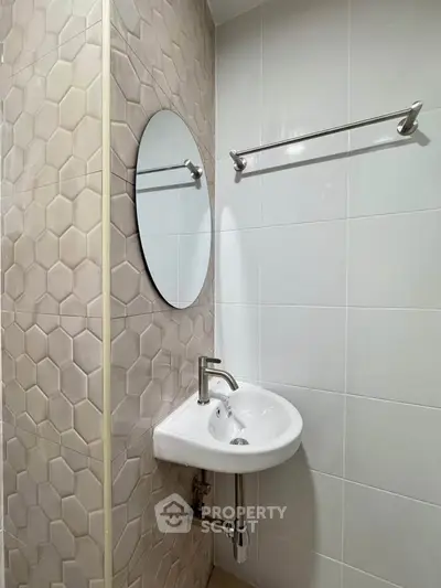 Modern bathroom with stylish hexagonal tiles and sleek round mirror