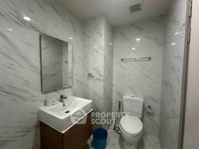 Modern bathroom with marble walls and sleek fixtures in a contemporary apartment.