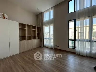 Spacious modern living room with high ceilings and large windows for natural light.
