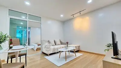 Modern living room with cozy sofa and dining area in open layout apartment.
