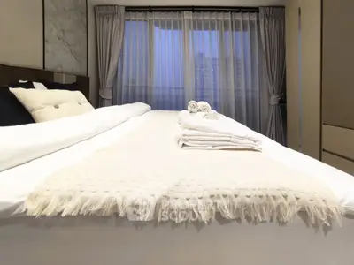 Luxurious bedroom with elegant decor and large windows offering city views.