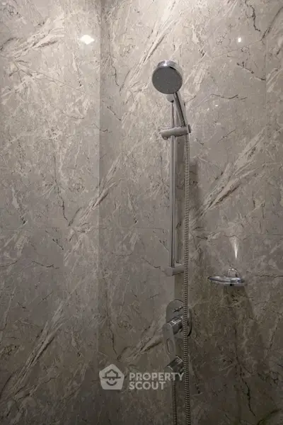 Luxurious marble shower with modern chrome fixtures in elegant bathroom