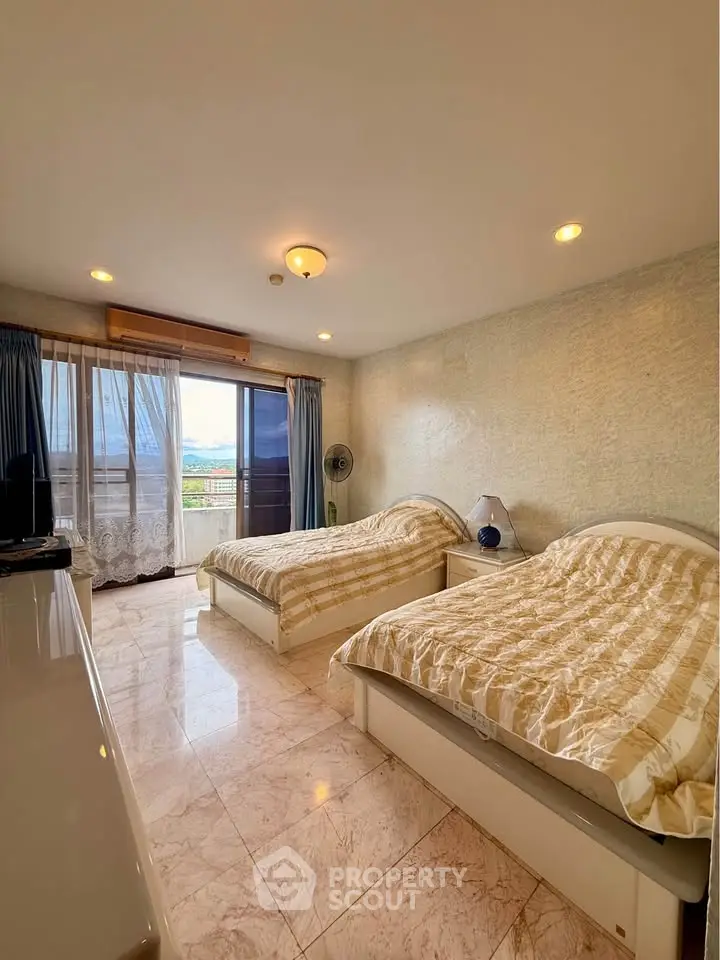 Spacious bedroom with twin beds and balcony view in modern apartment