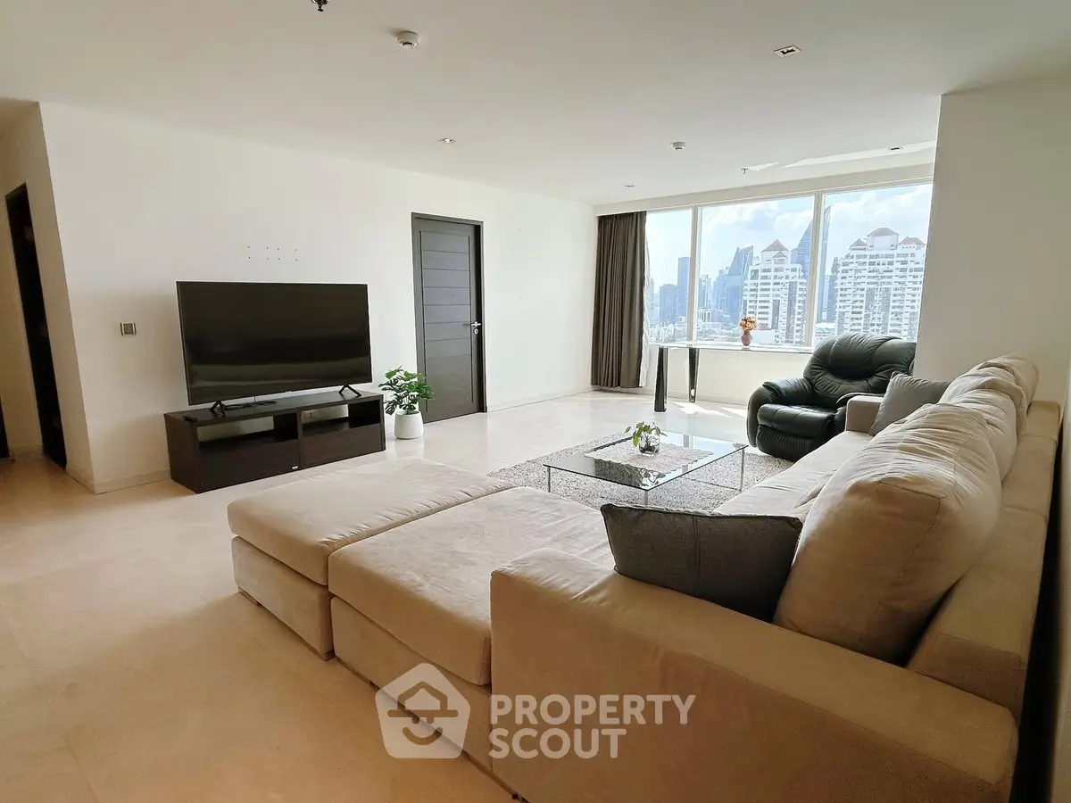 Spacious modern living room with city view, large sofa, and sleek TV setup.