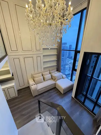 Luxurious living room with chandelier and city view in modern high-rise apartment.