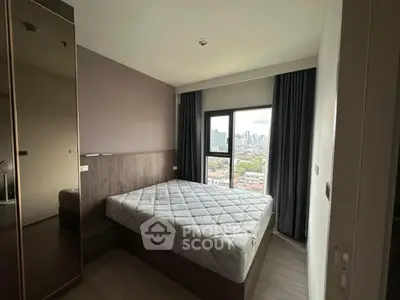 Modern bedroom with city view and large window, featuring a comfortable bed and stylish decor.