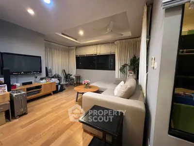 Spacious living room with modern decor and wooden flooring, perfect for relaxation and entertainment.