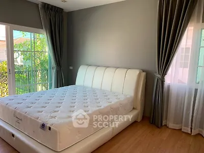 Spacious bedroom with elegant decor and large windows for natural light.