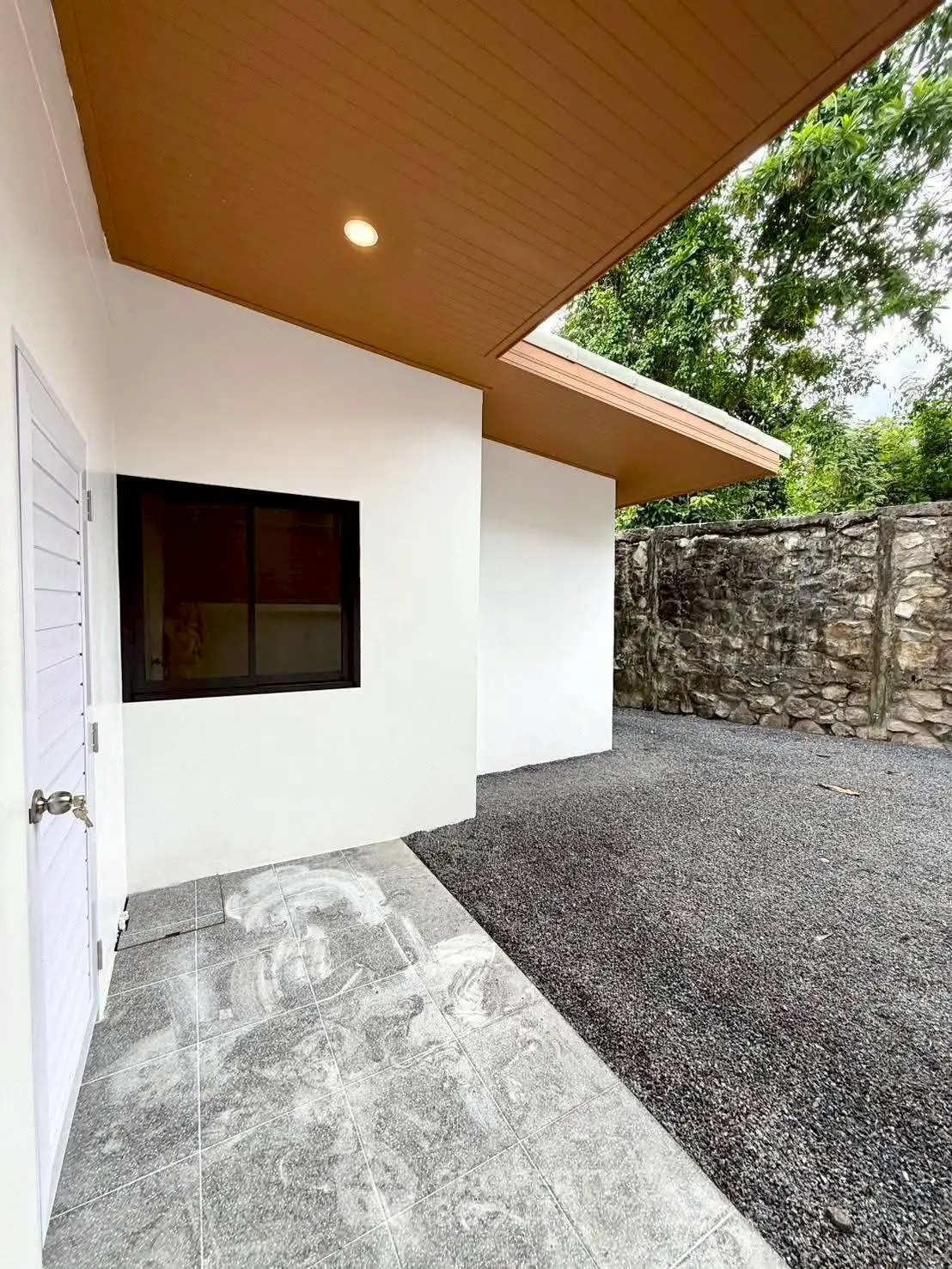 Modern exterior with stone wall and sleek design, perfect for contemporary living.