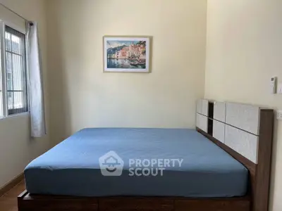 Cozy bedroom with large window and stylish bed frame, perfect for relaxation.