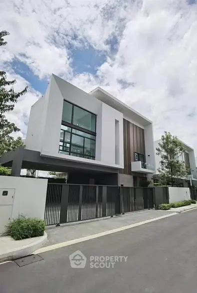 Modern luxury house with sleek design and large windows in a serene neighborhood.