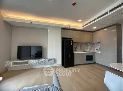 Modern living room with sleek kitchen, featuring marble accents and integrated appliances.