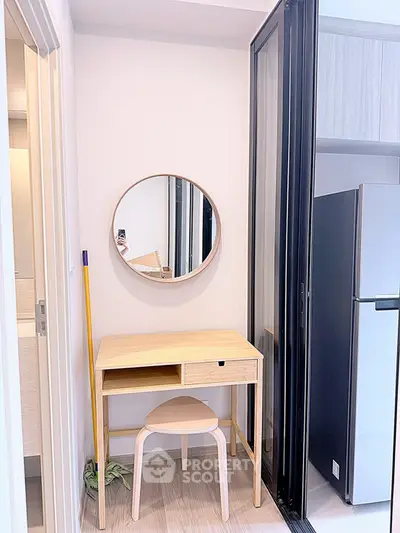 Modern compact study nook with wooden desk and round mirror in a stylish apartment.