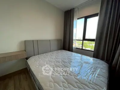 Modern bedroom with large window and comfortable bed, offering a bright and inviting atmosphere.