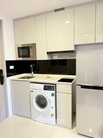 Modern kitchen with sleek appliances and integrated washing machine