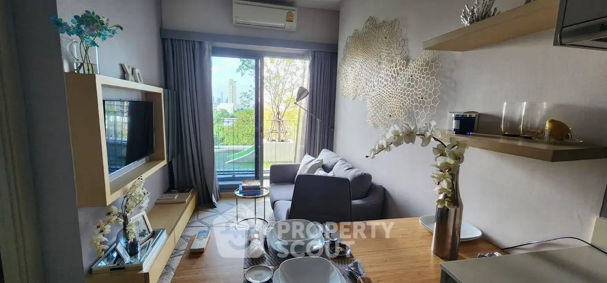 Modern living room with balcony view, stylish decor, and open layout in urban apartment.