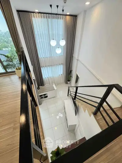 Modern duplex interior with elegant staircase and large windows
