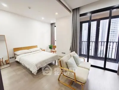 Spacious bedroom with modern decor and city view balcony.
