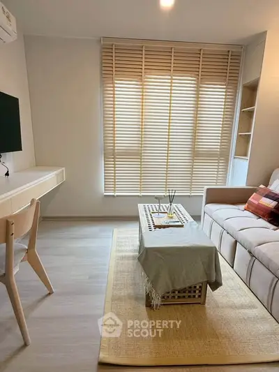 Modern living room with stylish decor and natural light, featuring a cozy sofa and elegant blinds.