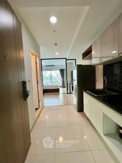 Modern open-layout kitchen with sleek appliances and view into spacious living area.