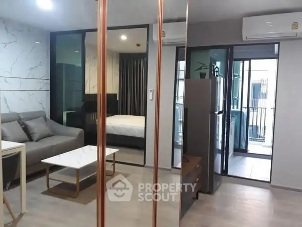 Modern apartment interior with living room, bedroom, and balcony view, featuring sleek design and air conditioning.