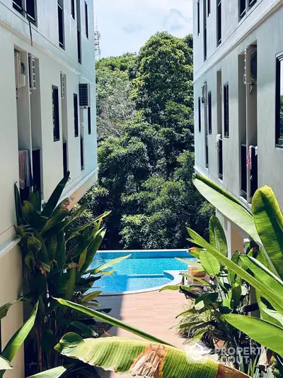 Stunning pool view between modern apartment buildings with lush greenery