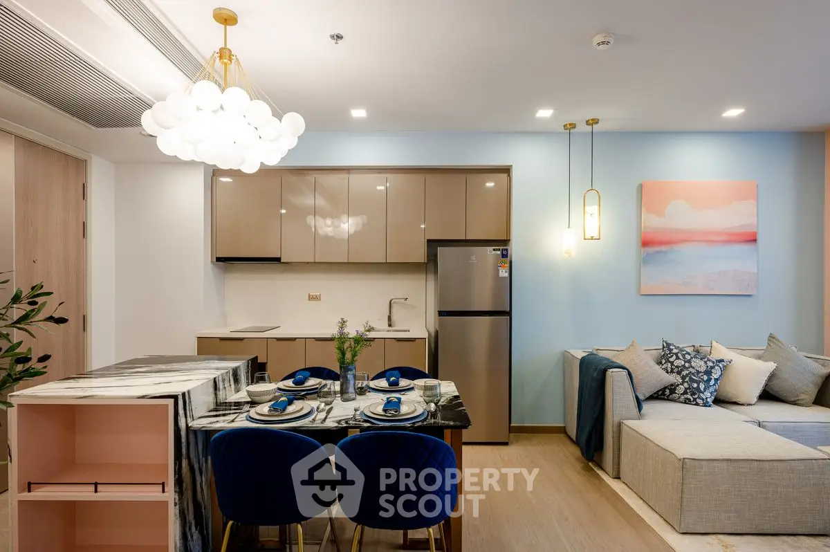 Modern open-plan living room and kitchen with stylish decor and elegant lighting.