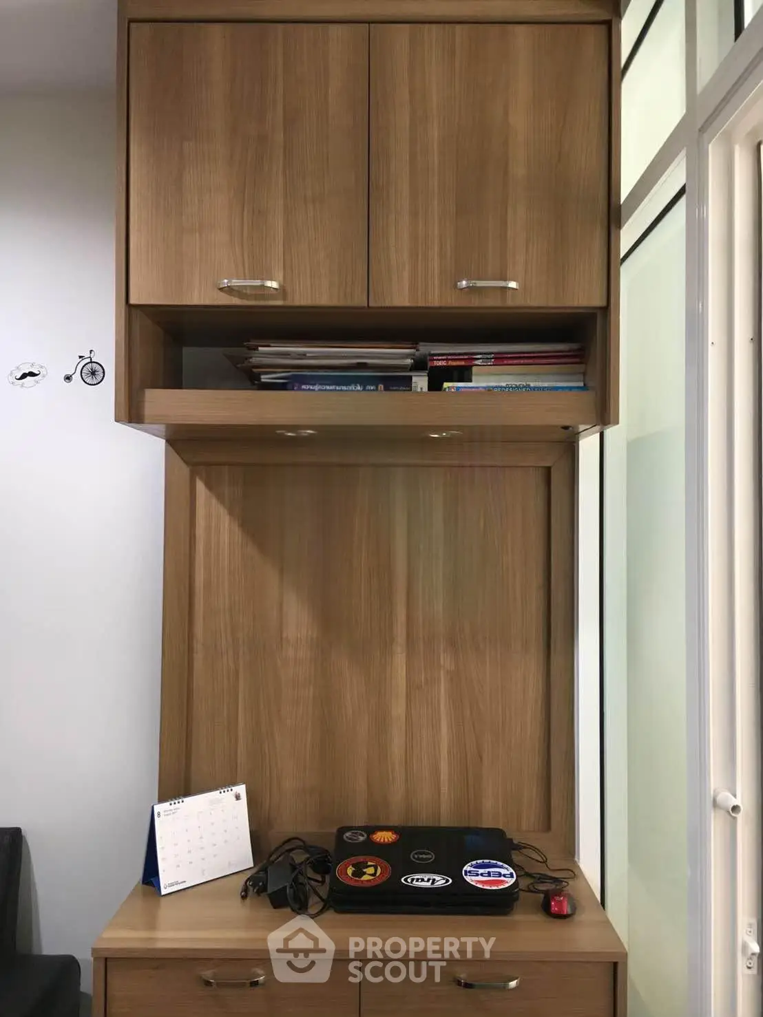 Modern study area with wooden cabinets and workspace featuring a laptop and calendar.