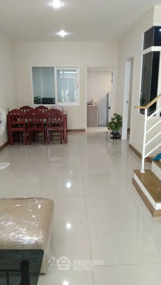 Spacious living room with dining area and staircase in modern home