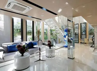 Luxurious modern living room with elegant decor and large windows offering garden views.