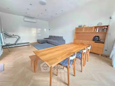Spacious living room with modern furniture and exercise equipment, perfect for relaxation and fitness.
