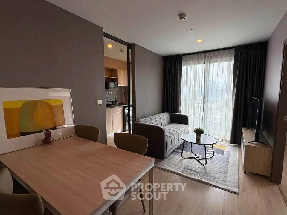 Modern living room with stylish decor and open kitchen layout in a high-rise apartment.