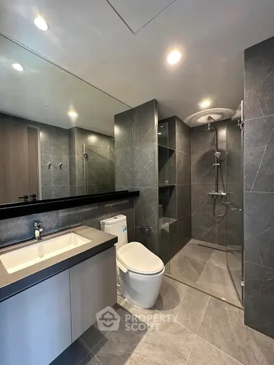 Modern bathroom with sleek design, featuring a glass shower and stylish fixtures.