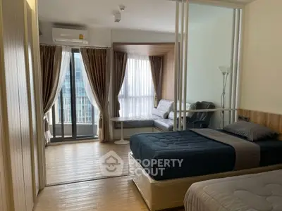 Modern bedroom with balcony and cozy seating area in a stylish apartment.