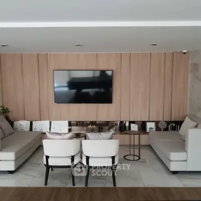 Modern living room with sleek design and wall-mounted TV, featuring elegant seating and stylish decor.
