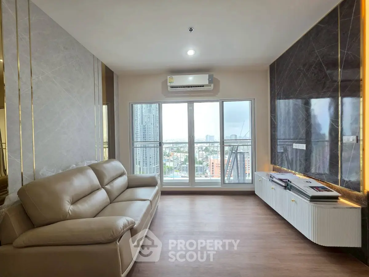 Modern living room with city view, featuring sleek furniture and large windows for natural light.