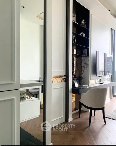 Modern study area with sleek design and city view, featuring elegant furniture and built-in shelving.