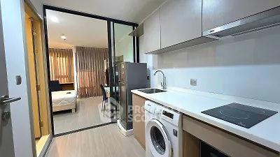 Modern kitchen with washing machine and induction stove in stylish apartment
